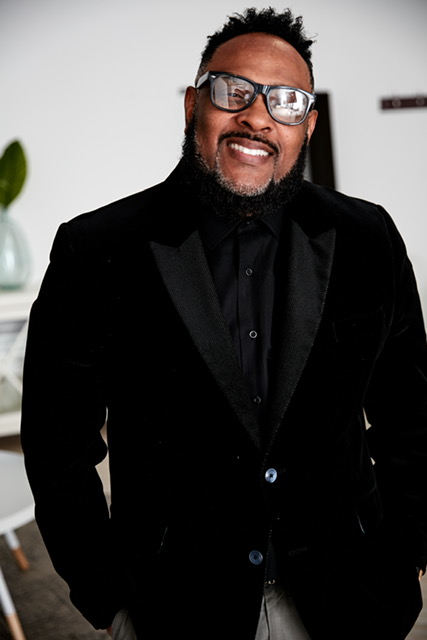 Q Ballard, President of AutoFlow, in a professional black blazer