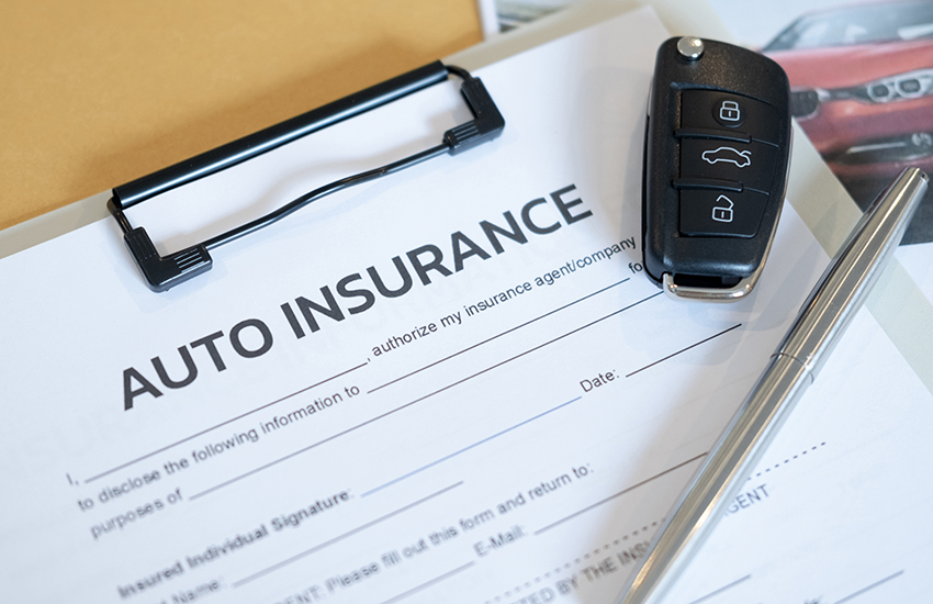 Auto insurance form with car key and pen — comprehensive coverage documentation for vehicle transport