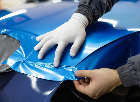 Professional vehicle wrap being applied at a wrap shop